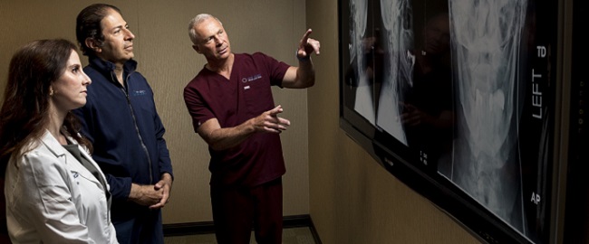 three physicians reviewing x-rays