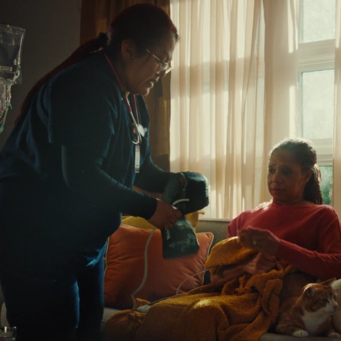 Healthcare worker assisting patient at home