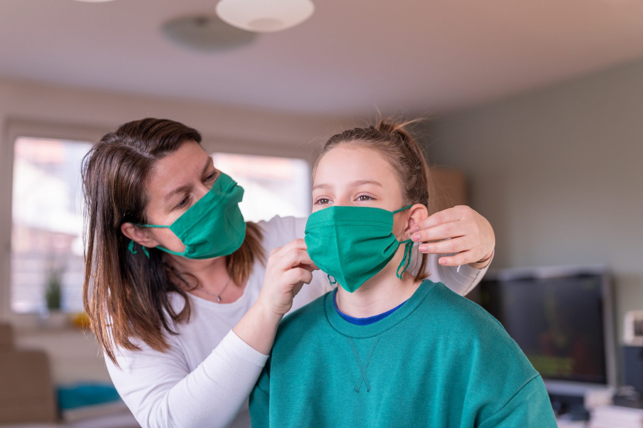 Woman Putting a Mask on Her Child