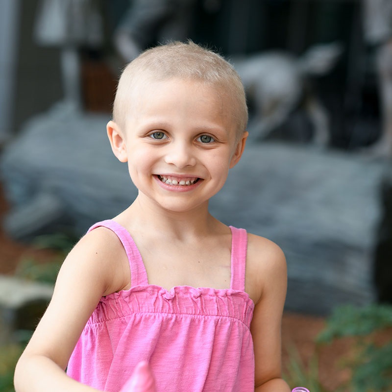 Young girl smiling with no hair