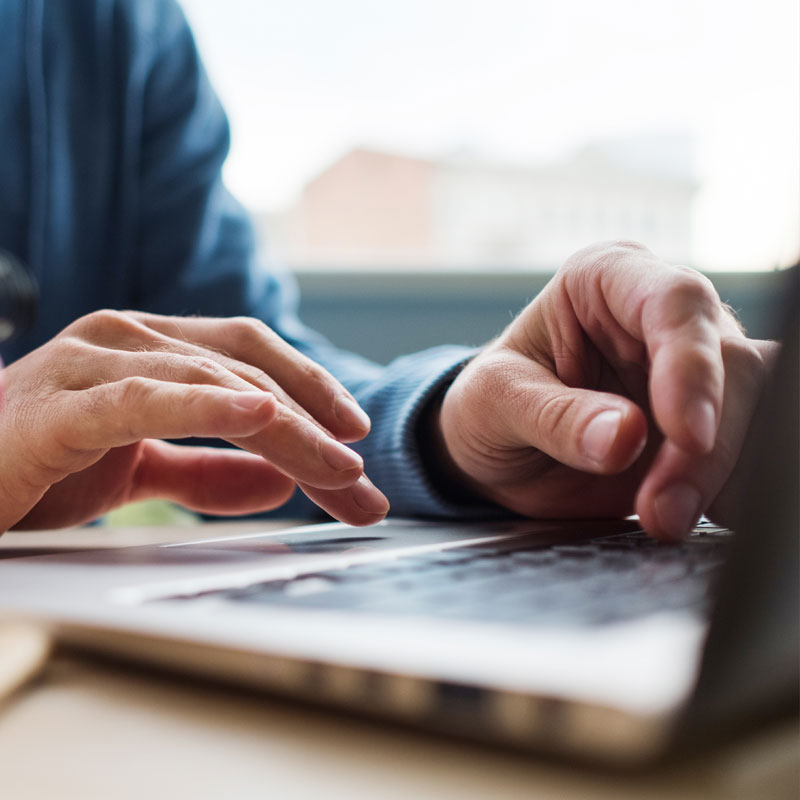 hands typing on a laptop