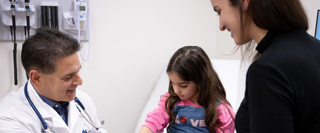 physician with mom and her child during exam