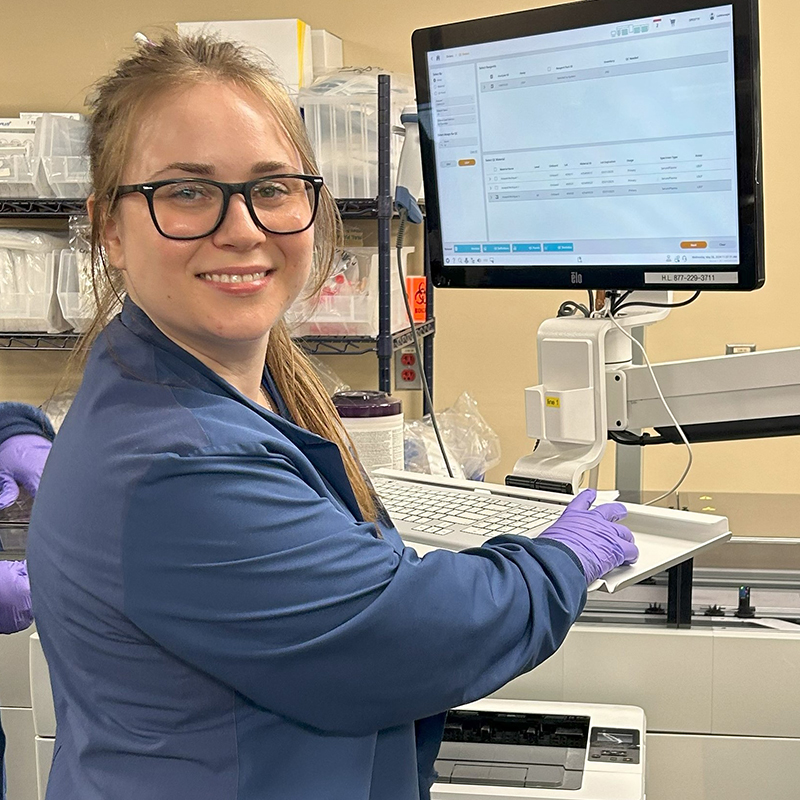 Female student standing by monitor.
