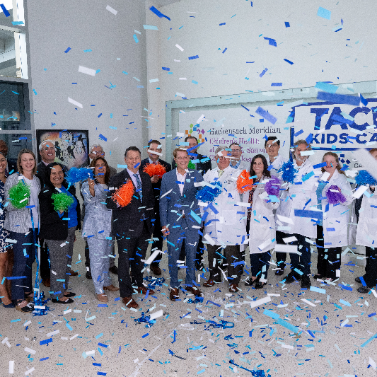 A group of physicians celebrating with confetti and and pom poms. 