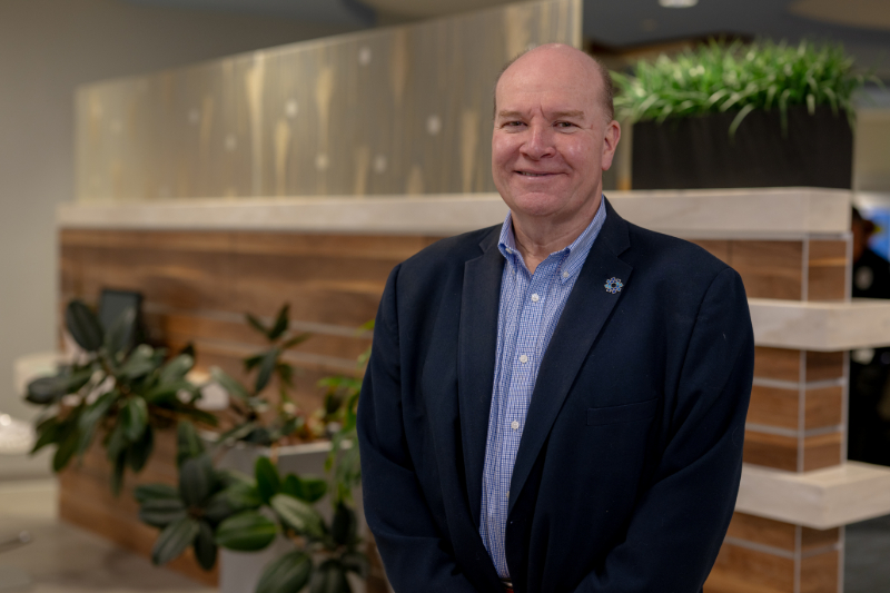 Jim Young, a leader in hospital fundraising, standing smiling in the lobby of Southern Ocean Medical Center
