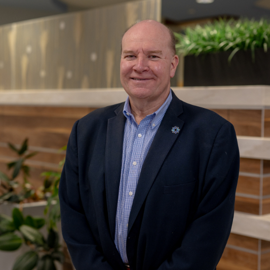 Jim Young, a leader in hospital fundraising, standing smiling in the lobby of Southern Ocean Medical Center