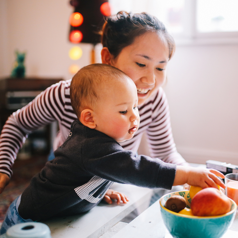 Mom and child reaching for fruit