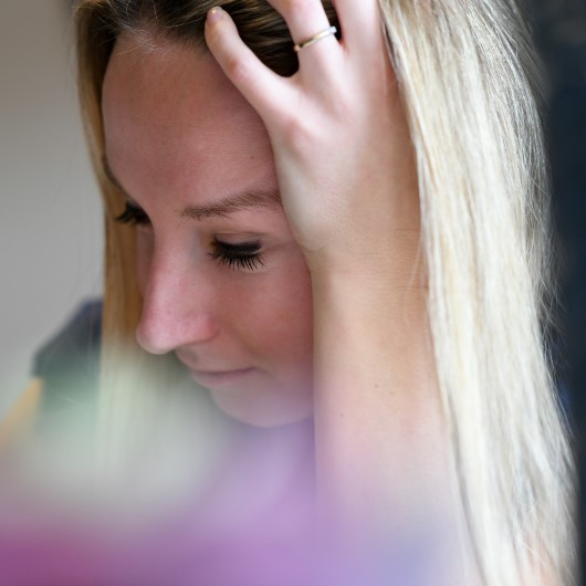 young Caucasian woman grabs head with fear of concussion