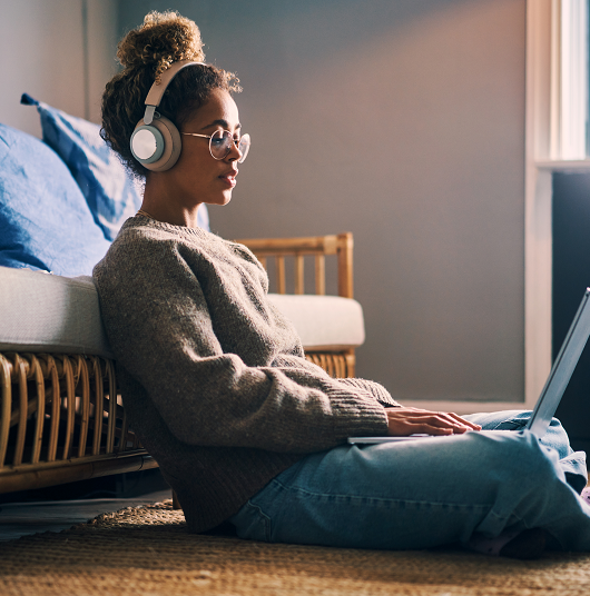 Young woman listening to loud music with headphones while on her laptop. 