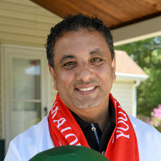 Hany M. Gendy, M.D., internal medicine specialist and international soccer fan, smiling and holding a soccer ball