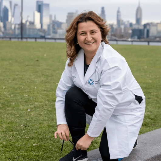 Family medicine specialist Anna Derian, M.D., crouches down to tie her shoe.