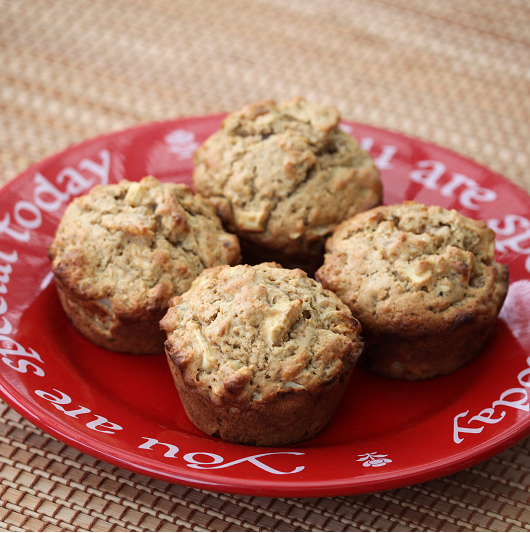 Applesauce walnut muffins on a red dish on a table. 