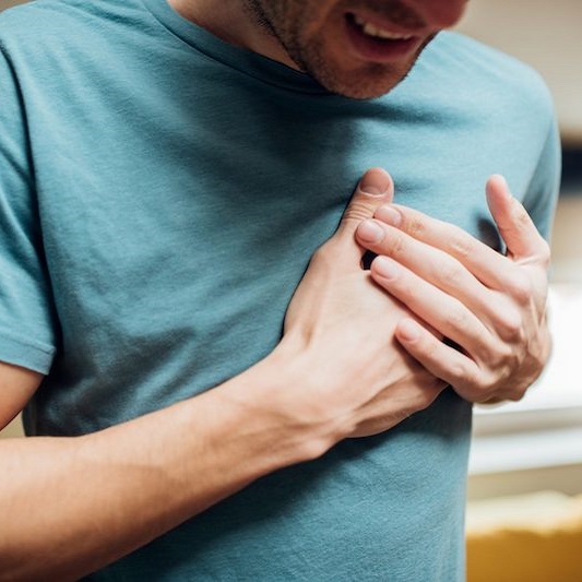 young man holding his chest