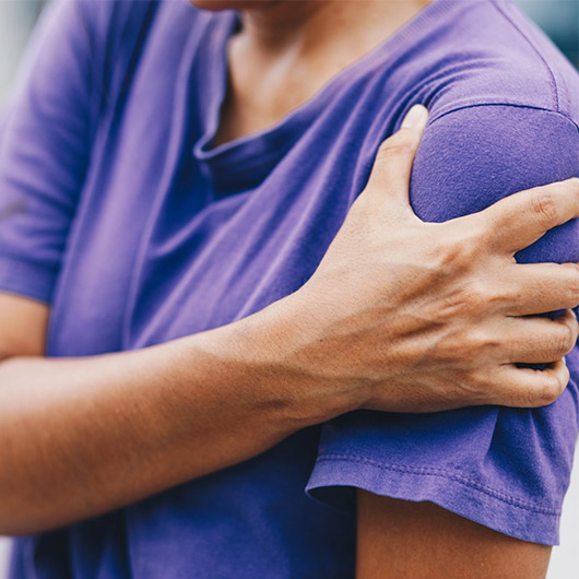 Hand holding painful shoulder