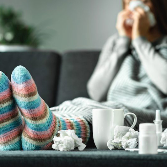 Women not feeling well using a tissue.