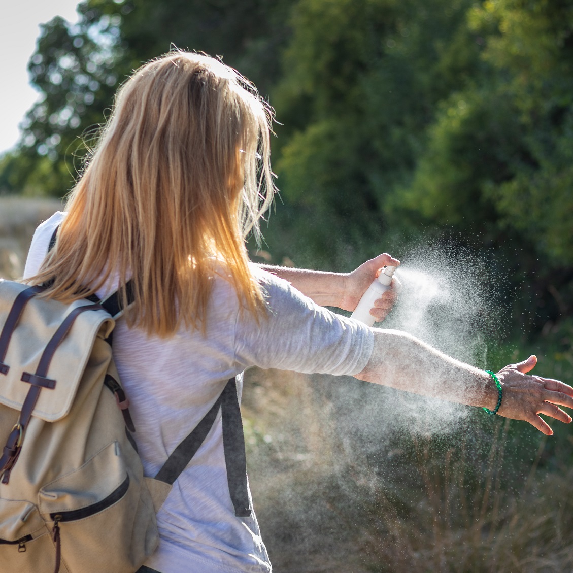 person spraying bug spray