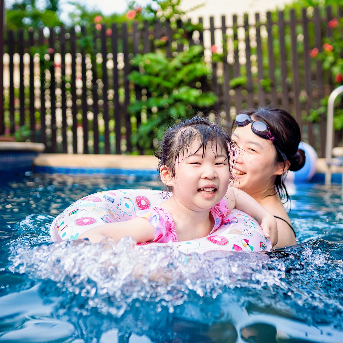 parent and child swimming in pool