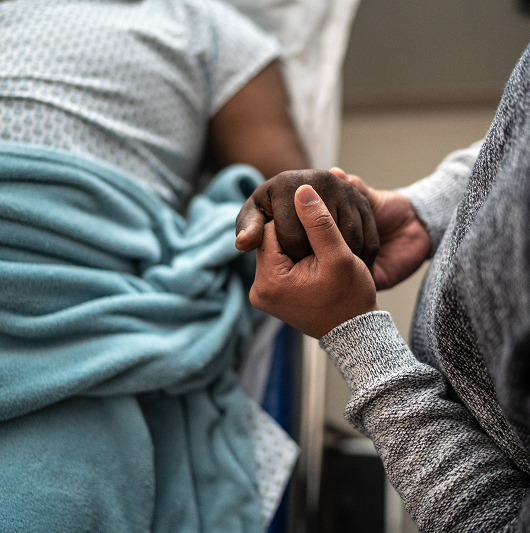 visitor holding patient's hand