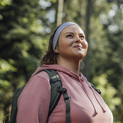 Happy woman with a backpack spending a day in nature.