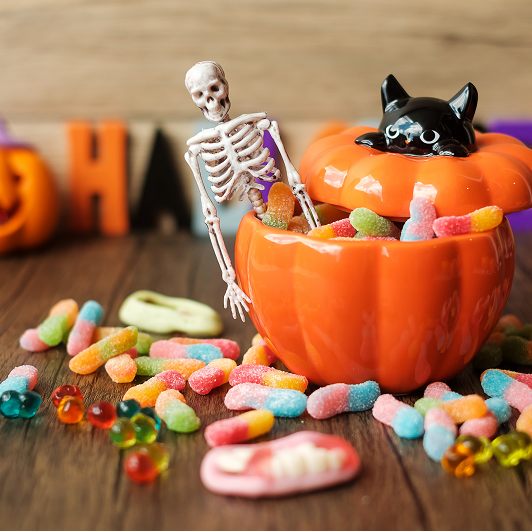 Halloween candy, ghost candies, pumpkin bowl, Jack O lantern and decorative set up.