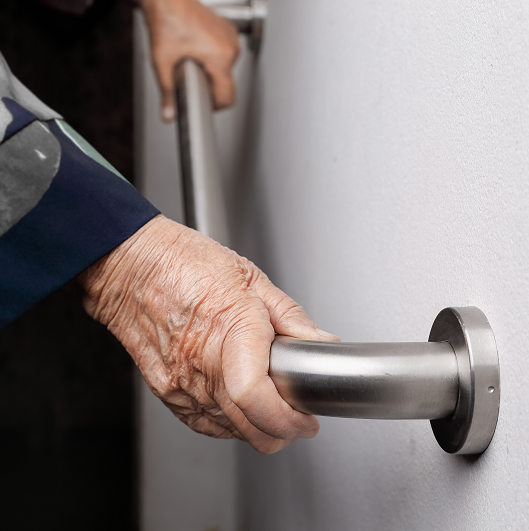 Elderly woman holding on handrail for safety walk steps in the home.