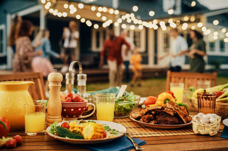 Backyard table with barbeque foods laid out.