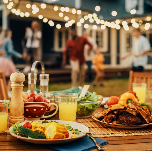 Backyard table with barbeque foods laid out.