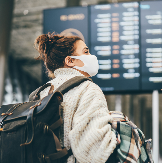 Young woman wearing a mask while traveling during the holiday season.
