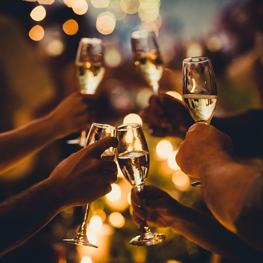 Numerous hands holding champagne flutes with champagne celebratory toast silhouettes