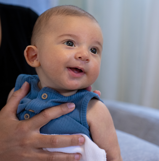 Young baby being held by his mother.