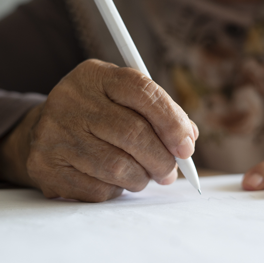 Person's hands as they take notes ahead of a doctor's appointment, writing down concerns