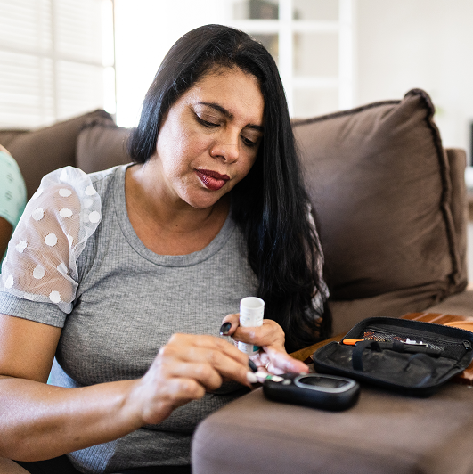 Woman checking blood sugar level at home, signs of diabetes in women
