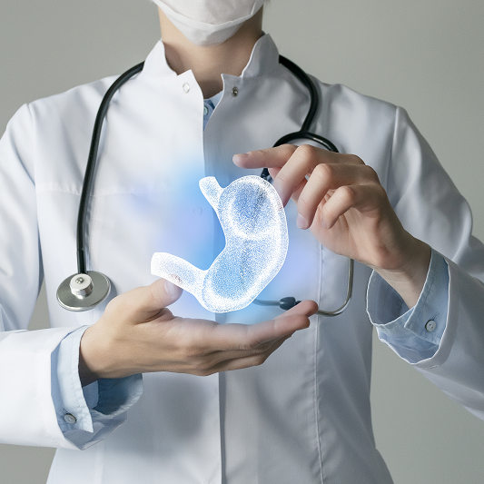 Doctor's hands holding up a graphic of a stomach, illustrating acid reflux