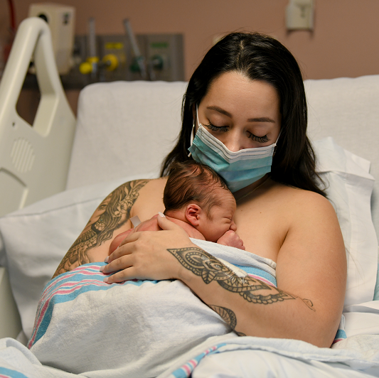 Mother holding her newborn baby on her chest. 