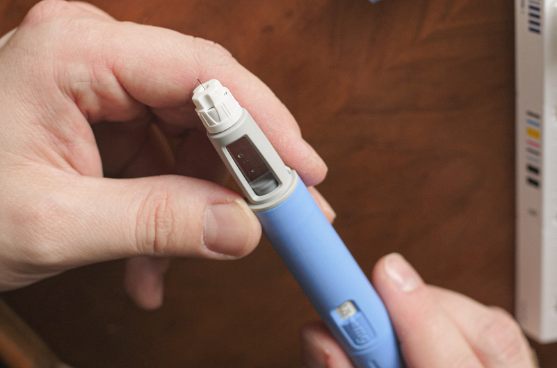 A caretaker prepares a weight-loss drug injection for a child
