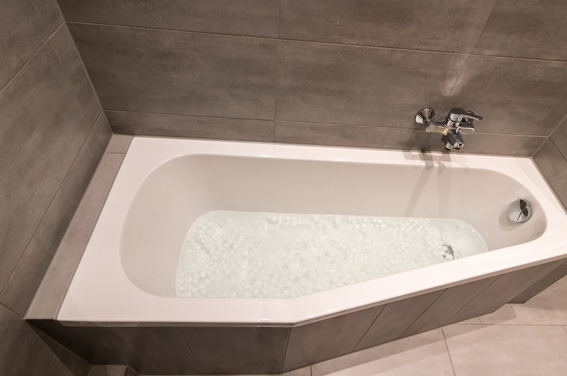 Bathtub filled with cold water and ice cubes for recovery reasons