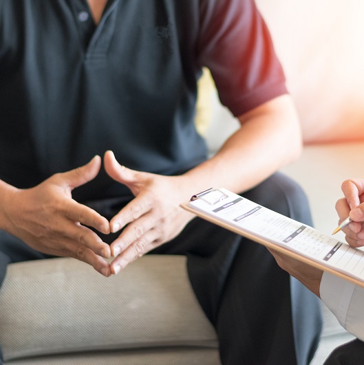 Doctor giving consult to a patient, discussing testicular lumps and cancer.