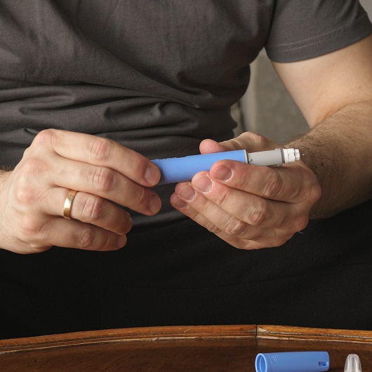 Man preparing Ozempic injection control blood sugar levels and obesity.