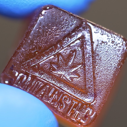 A close-up of a cannabis gummy with a THC warning.