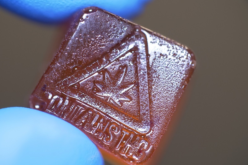 A close-up of a cannabis gummy with a THC warning.