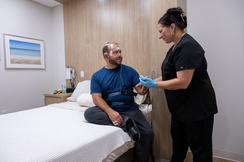Sleep center technician helping the patient get set up for a sleep study.