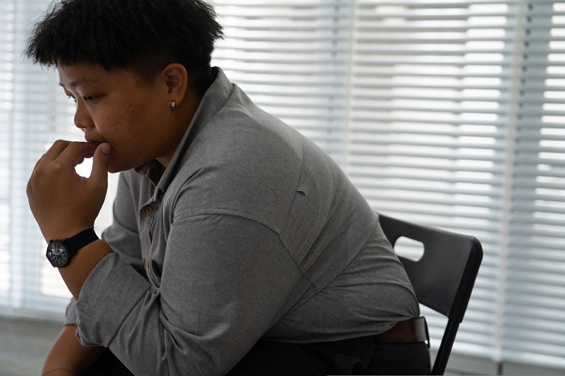Stressed young man sitting in a chair thinking.