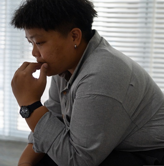 Stressed young man sitting in a chair thinking.