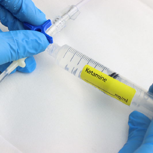 Professional wearing gloves injecting ketamine to be taken intravenously.
