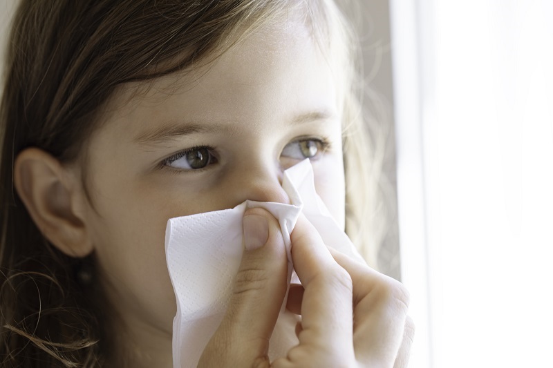 Close up shot of a mother holding a child's nose to stop a nosebleed.