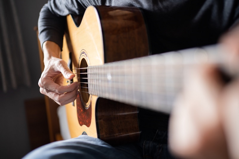 Close up shot of an acoustic guitar being played.