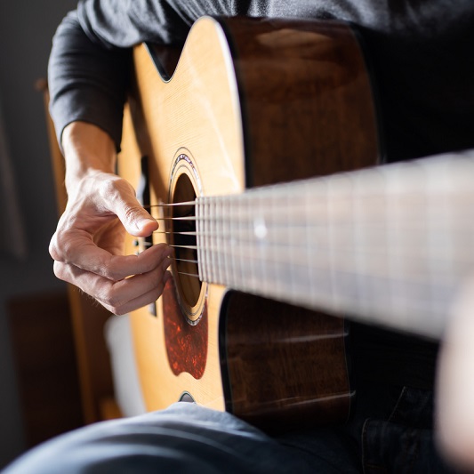 Close up shot of an acoustic guitar being played.