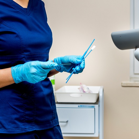 Gynecologist holds instruments for taking a pap smear. In the OBGYN office.