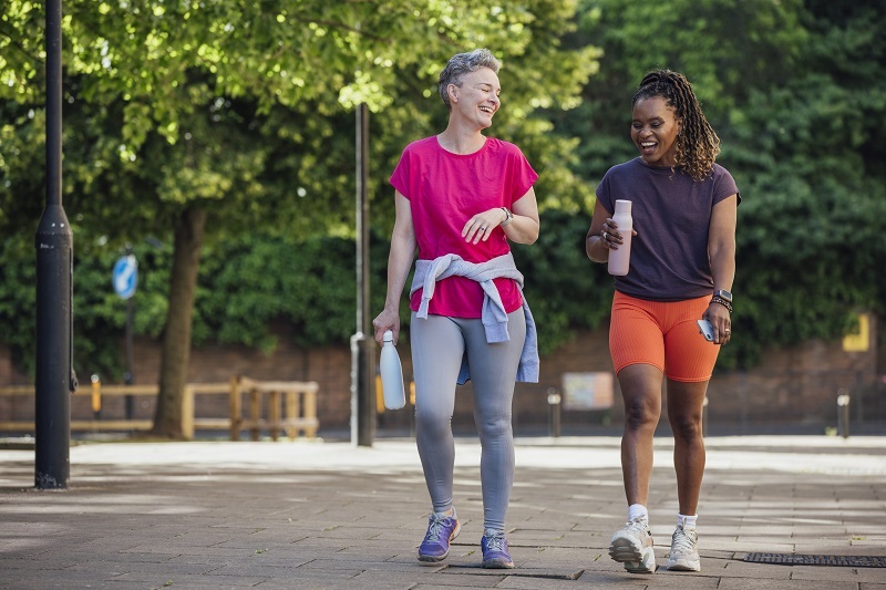 Two women smiling and walking.