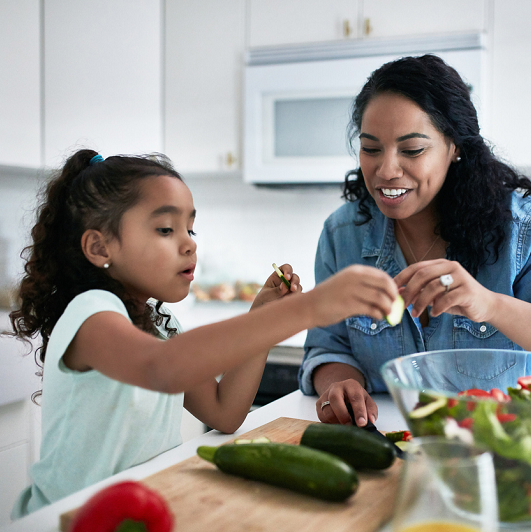 Mom and daughter preparing a healthy meal together.